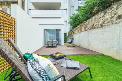 a patio with a couch and a table on a lawn at Luxury in the Art District by Innkeeper in Porto