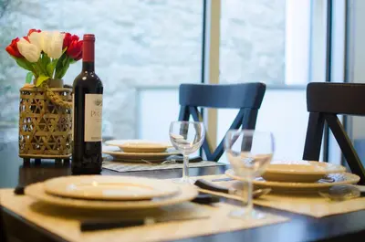 a table with a bottle of wine and plates and glasses at Apartments Porto Historico in Porto