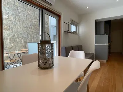 a room with a table with white chairs and a kitchen at Apartments Porto Historico in Porto