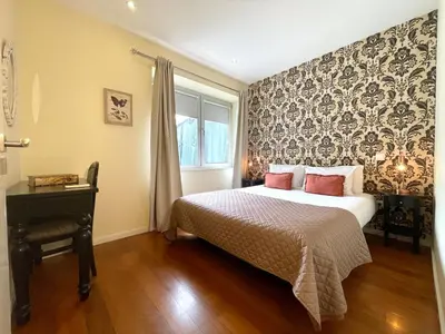 a bedroom with a bed and a window and a desk at Apartments Porto Historico in Porto