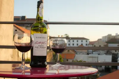 a bottle of wine and two glasses on a table at Apartments Porto Historico in Porto
