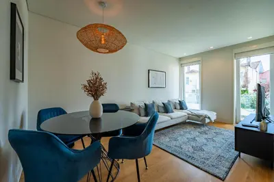 a living room with a table and blue chairs at L'atelier L - Quartier des Arts in Porto