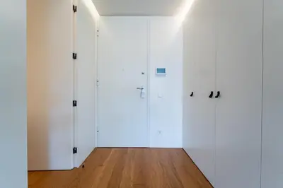 an empty room with white doors and a wooden floor at L'atelier L - Quartier des Arts in Porto