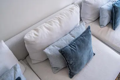 a white couch with three pillows on it at L'atelier L - Quartier des Arts in Porto