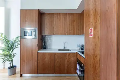 a kitchen with wooden cabinets and a sink at Monte dos Judeus 26 by LovelyStay in Porto