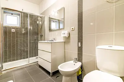 a bathroom with a toilet and a shower and a sink at Porto Central Home in Porto
