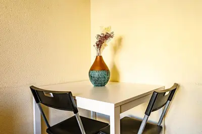a vase sitting on a table with two chairs at Porto Central Home in Porto