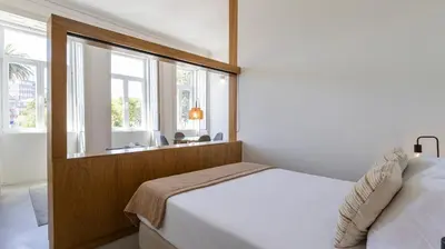 a bedroom with a bed and a large window at OPOrto Downtown Studio by LovelyStay in Porto