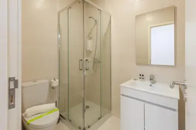 a bathroom with a shower and a toilet and a sink at Villa Apartments & Suites in Porto