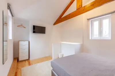 a white bedroom with a bed and a window at Villa Apartments & Suites in Porto