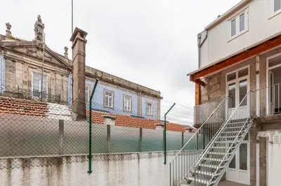 an old building with a fence in front of it at Villa Apartments & Suites in Porto