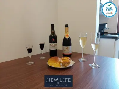 a table with two bottles and two glasses of wine at New Life - PARQUE CIDADE STUDIO-0T in Porto