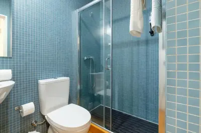 a bathroom with a toilet and a glass shower at GuestReady - Bolhão Market Place in Porto