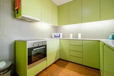 a kitchen with green cabinets and a stove at GuestReady - Bolhão Market Place in Porto
