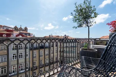 a balcony with two benches and a building at The Mouzinho Penthouse in Porto