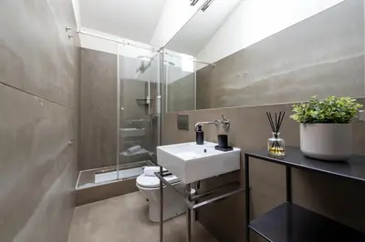 a bathroom with a white sink and a toilet at The Mouzinho Penthouse in Porto