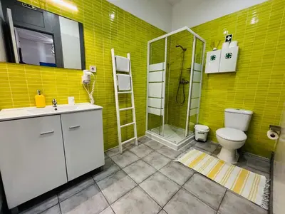 a yellow bathroom with a toilet and a shower at Douro sunset lounge in Porto