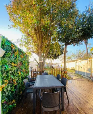 a table and chairs on a wooden deck with trees at Douro sunset lounge in Porto