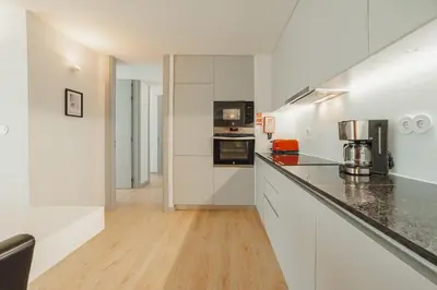 a kitchen with white cabinets and a counter top at Amazing Pool Apartments by Vacationy in Vila Nova de Gaia