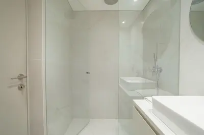 a white bathroom with a shower and a sink at Elegant Downtown Apartment by Vacationy in Porto