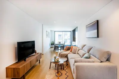 a living room with a couch and a flat screen tv at Camões Downtown with Parking in Porto