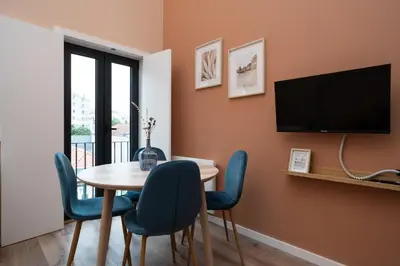 a dining room with a table and chairs and a television at Paraíso Apartment by Amber Star Rent in Porto