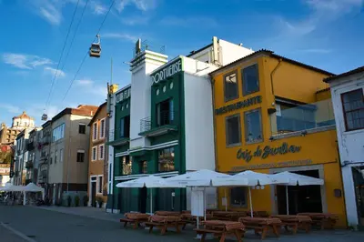 a building with tables and umbrellas on a street at WLoft in Vila Nova de Gaia