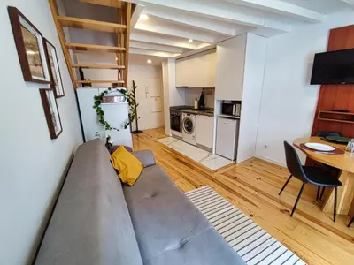 a living room with a couch and a table and a kitchen at WLoft in Vila Nova de Gaia