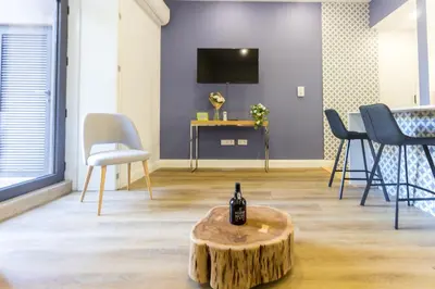 a room with a table with a bottle of wine on top of a tree stump at Guest H4U - Porto Bonfim Heroismo in Porto