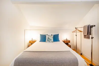 a kitchen with white cabinets and a table with chairs at Oporto Loft with Mezzanine in Porto