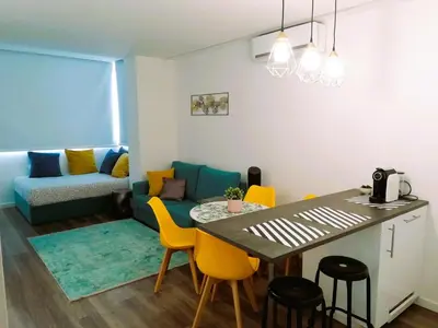 a kitchen and a living room with a table and chairs at Hey Porto Apartment in Porto