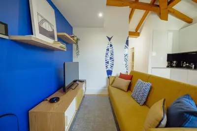 a living room with a yellow couch and a blue wall at Downtown Prime With Terrace by Vacationy in Porto