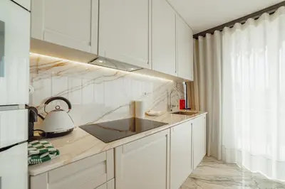 a kitchen with white cabinets and a sink at Downtown Penthouse With River View by Vacationy in Porto