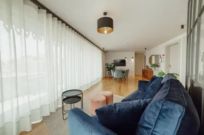 a living room with a blue couch and a table at Downtown Penthouse With River View by Vacationy in Porto