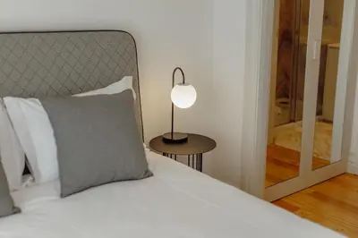 a bedroom with a bed with a lamp and a mirror at Downtown Penthouse With River View by Vacationy in Porto