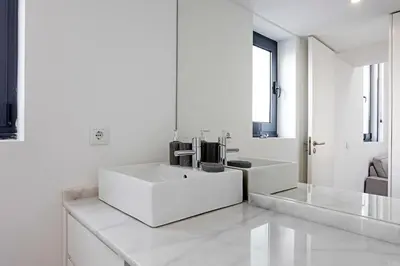 a white bathroom with a sink and a mirror at Cozy House w/ AC near metro by LovelyStay in Porto