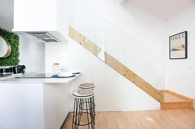 a staircase in a kitchen with a stool and a counter at Cozy House w/ AC near metro by LovelyStay in Porto