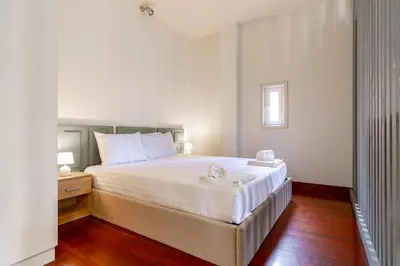 a bedroom with a large white bed and a wooden floor at Bonjardim Deluxe Loft in Porto