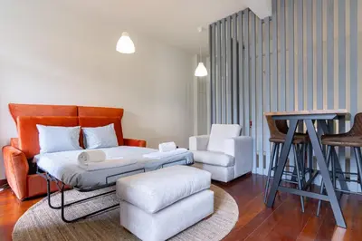 a living room with a bed and a chair at Bonjardim Deluxe Loft in Porto