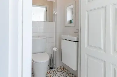a white bathroom with a toilet and a sink at Bonjardim Deluxe Loft in Porto