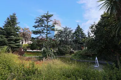a garden with trees and a building in the background at HM - Casa Ghiselini Porto 214 in Porto