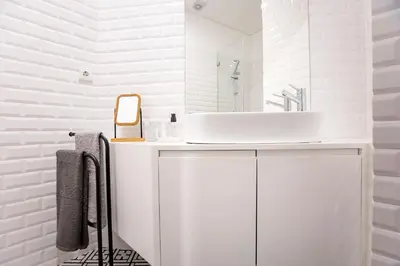 a white bathroom with a sink and a mirror at Downtown Wonder Flat w/ AC by LovelyStay in Porto