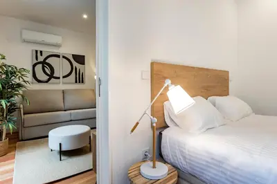 a bedroom with a bed and a lamp and a chair at Downtown Wonder Flat w/ AC by LovelyStay in Porto