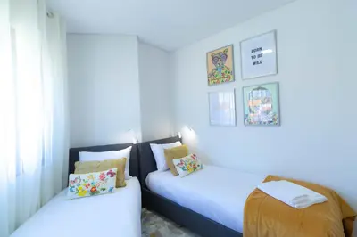 two beds in a room with white walls at 180º Porto River View in Vila Nova de Gaia