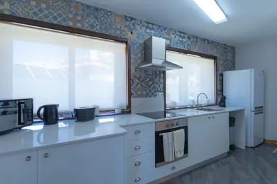 a kitchen with white counters and a refrigerator at 180º Porto River View in Vila Nova de Gaia