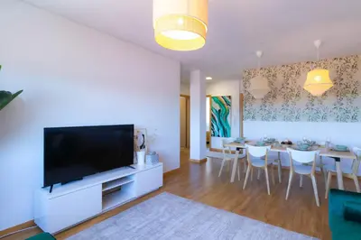 a living room with a large television and a dining room at 180º Porto River View in Vila Nova de Gaia