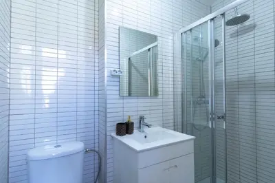 a bathroom with a toilet and a sink and a shower at 180º Porto River View in Vila Nova de Gaia