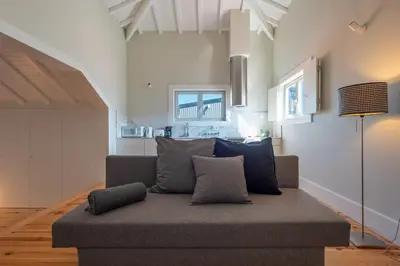 a living room with a couch with pillows on it at Oporto Rooftop Studio by Vacationy in Porto