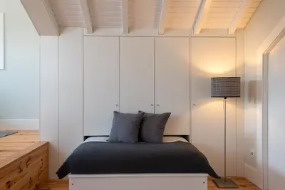 a bedroom with white cabinets and a bed at Oporto Rooftop Studio by Vacationy in Porto