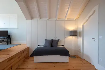a bedroom with a bed and a wooden floor at Oporto Rooftop Studio by Vacationy in Porto